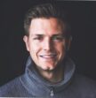 man smiling at camera on black background