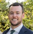 man wearing suit smiling at camera