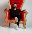 man sitting in red chair looking at camera
