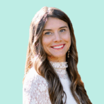 An image of a woman smiling with a white shirt and teal background.