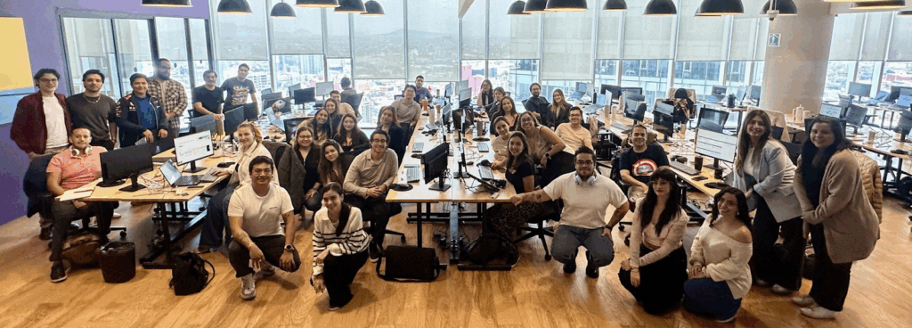 A group of people gathered in an office smiling.