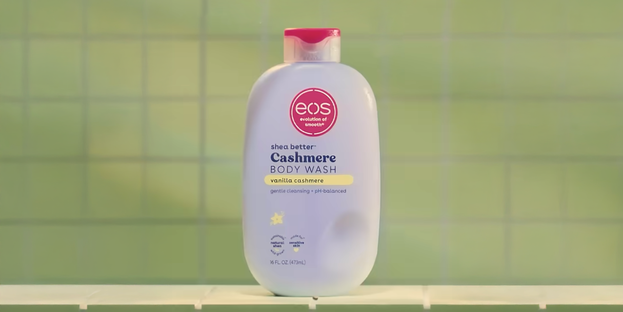 bottle of eos lotion against a green shower wall