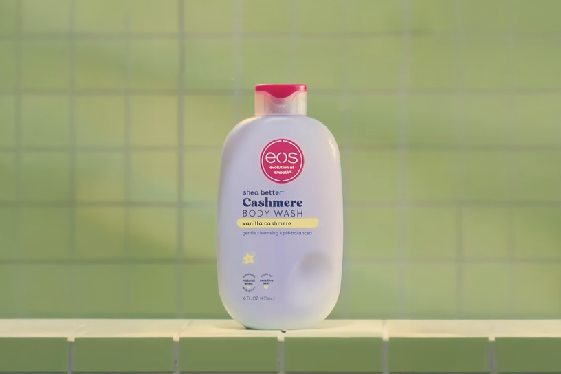 bottle of eos lotion against a green shower wall