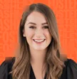 woman smiling in front of orange background