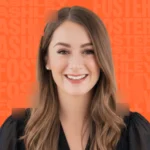 woman smiling in front of orange background