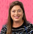 woman smiling in front of pink background