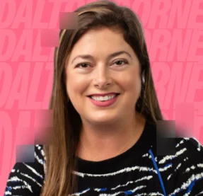 woman smiling in front of pink background
