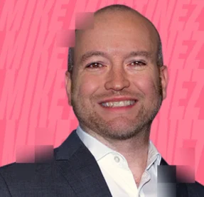 man smiling in front of pink background