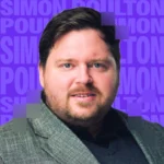 man smiling in front of purple background