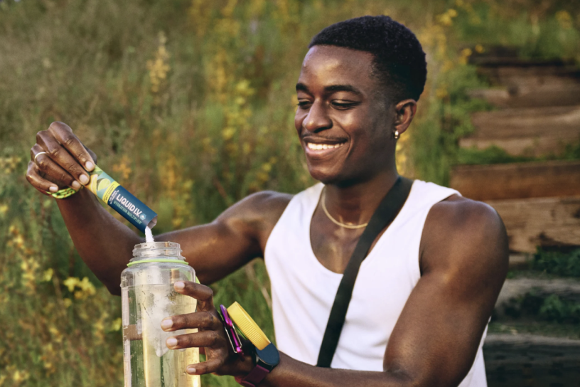 person pouring Liquid I.V. into a water bottle